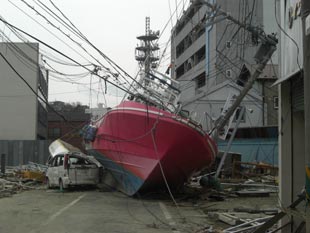 打ち上げられ道路をふさぐ船