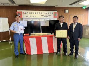 寄付者と受納者が記念撮影をしている写真です。
